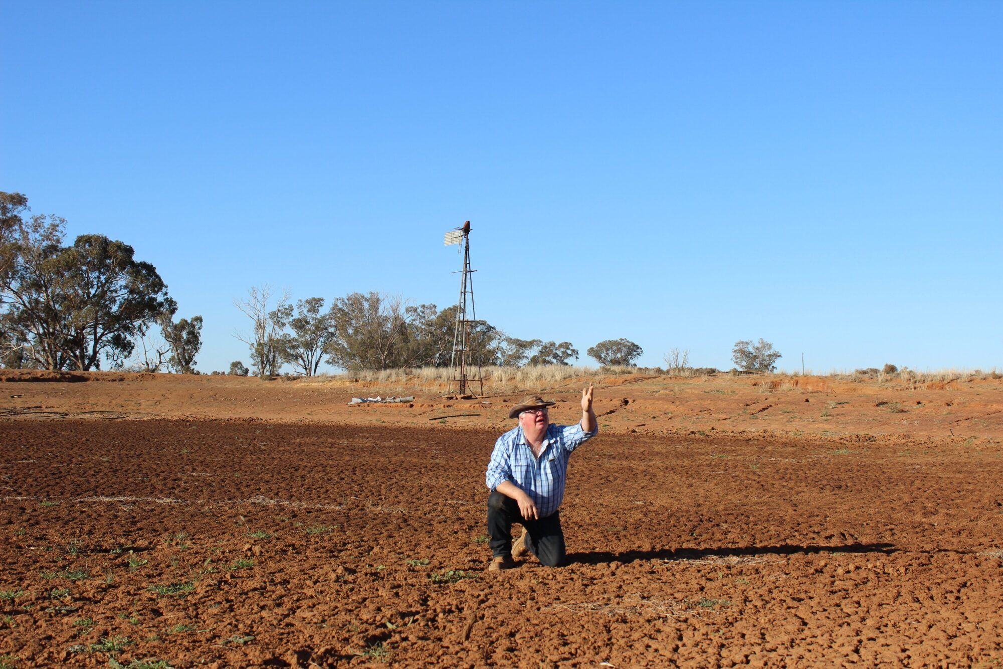 Farmer in Dry Dam with Hand upraised IMG 1951 scaled