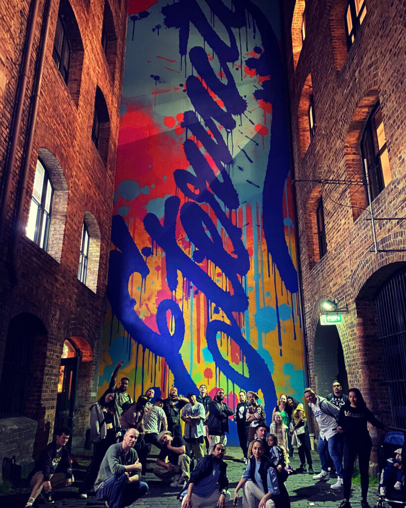 Some of the Krosswerdz crew in front of a huge piece painted by Mistery & Days One recognising the late Arthur Stace and his 'Eternity' artwork initiative